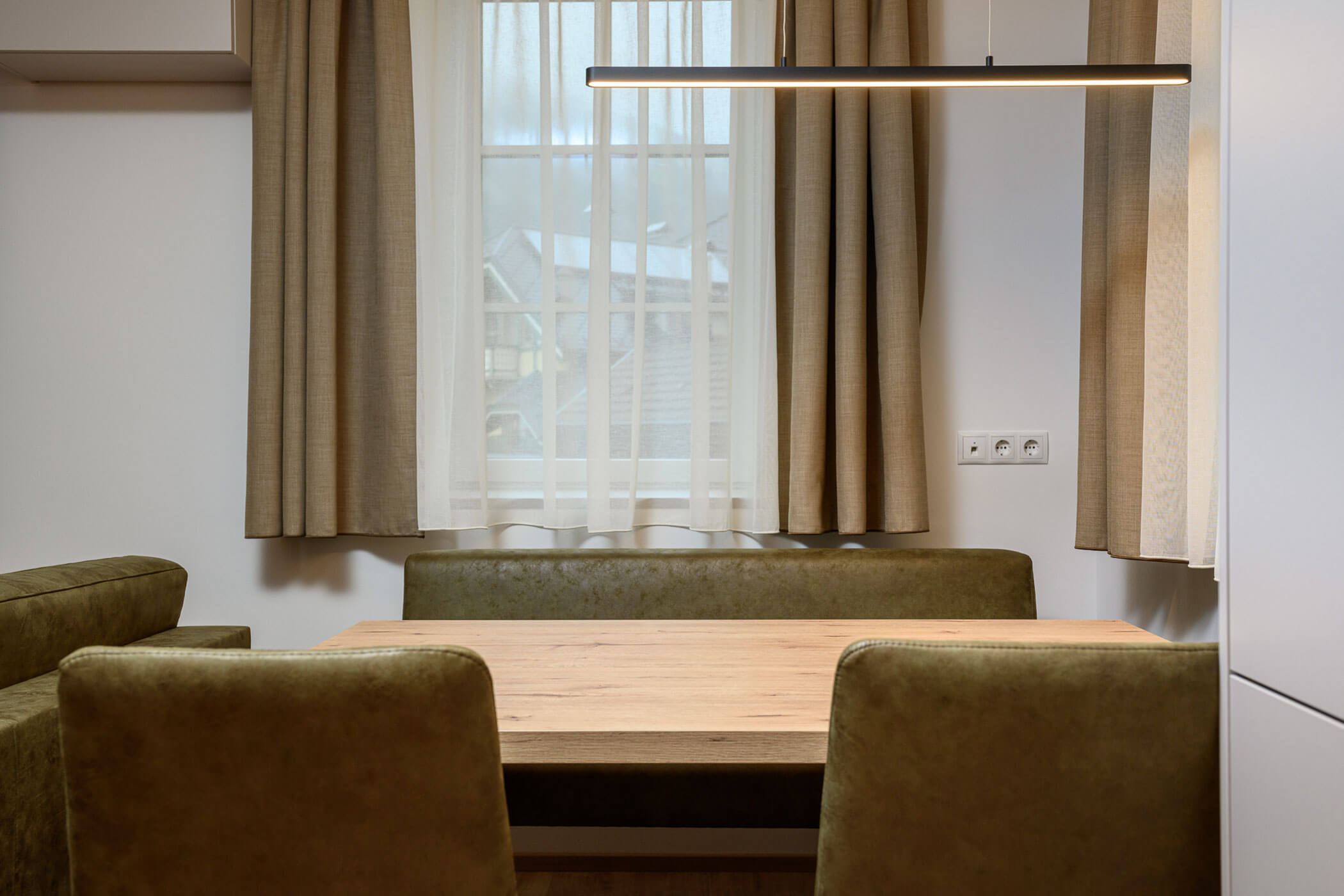 Dining table with green upholstery in Villa Fauster Apartment Linda