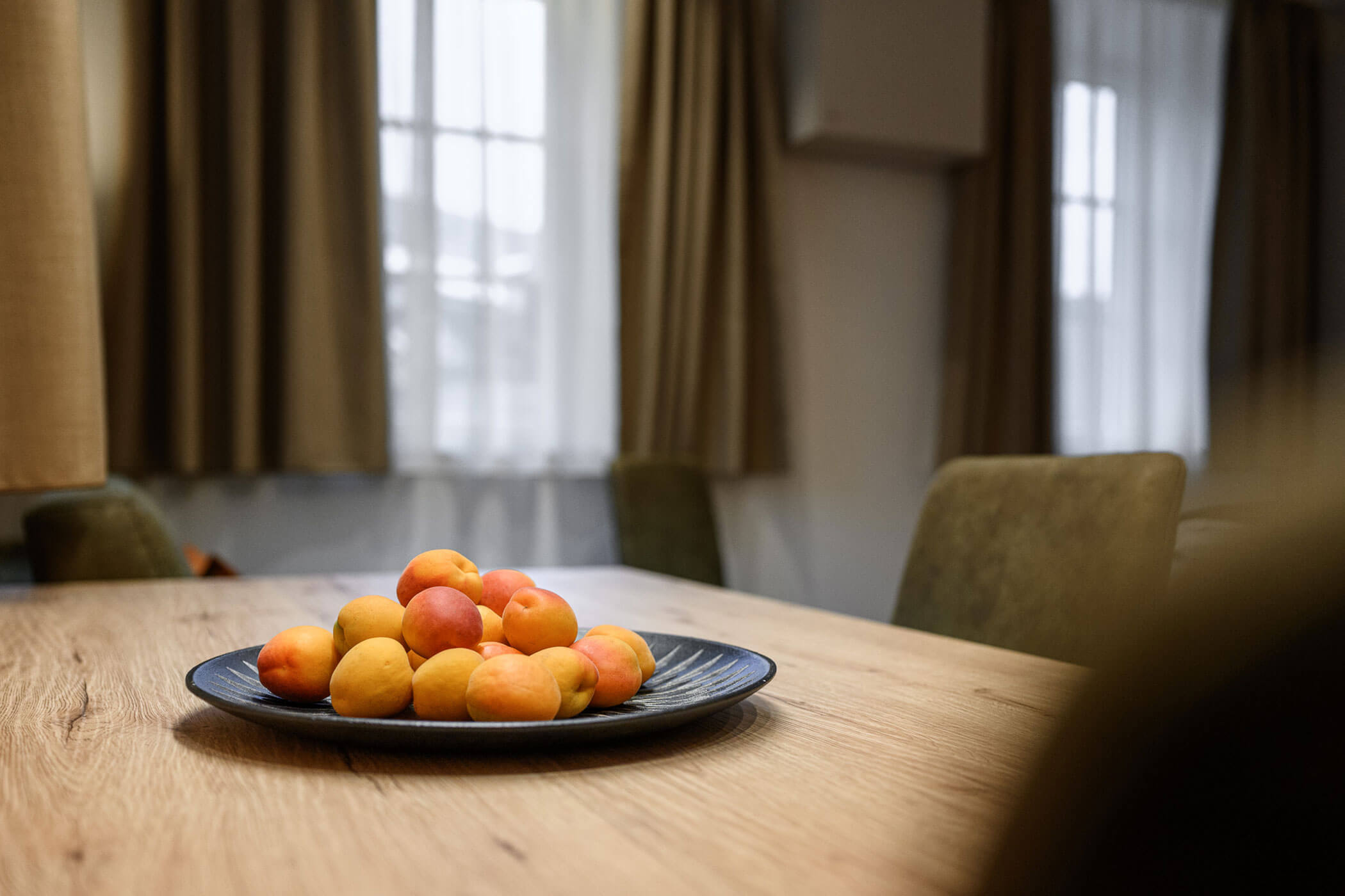 Dining table with a plate of apricots in Apartment Sophie