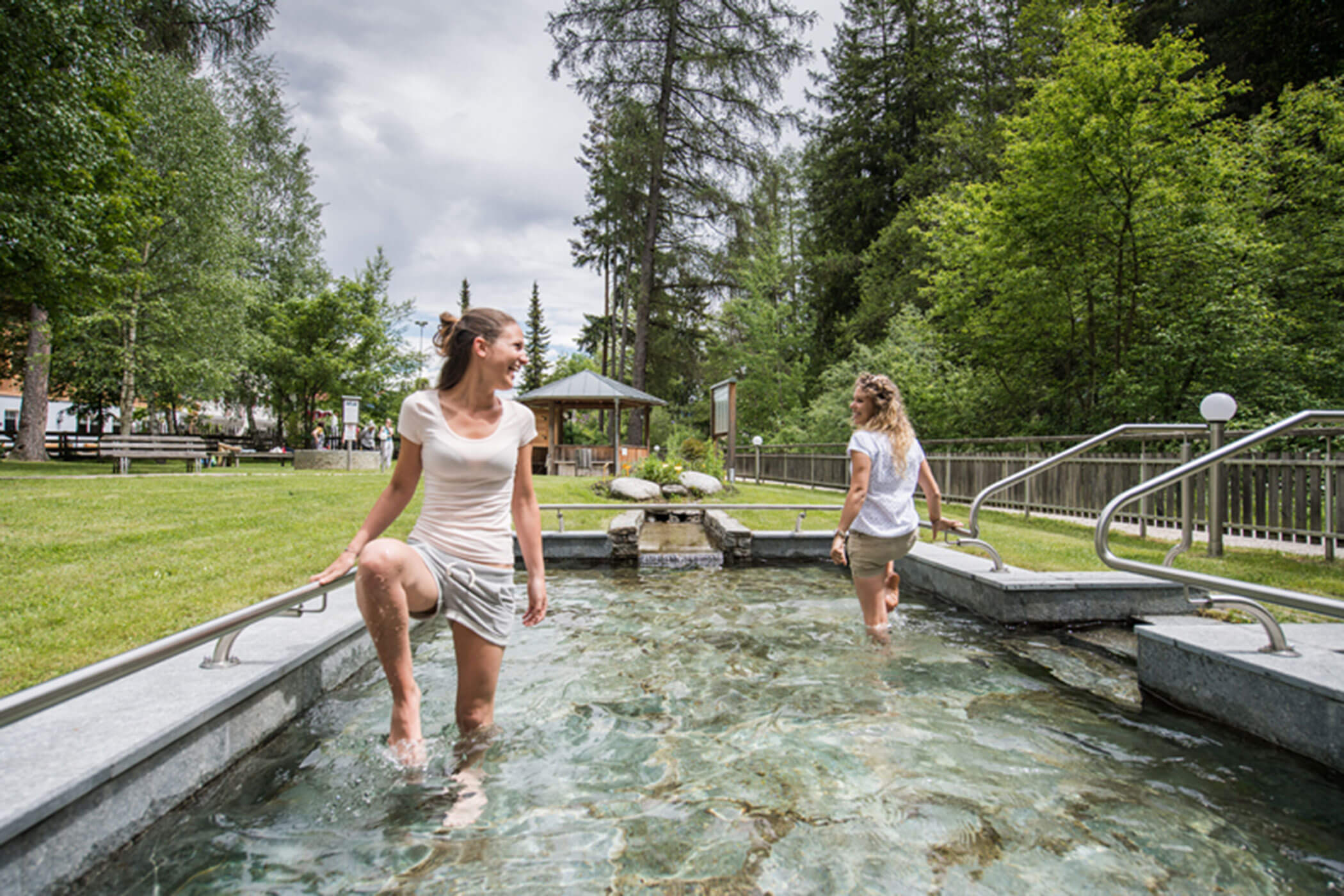 Due donne che fanno il bagno Kneipp nel Parco Kneipp di Villabassa